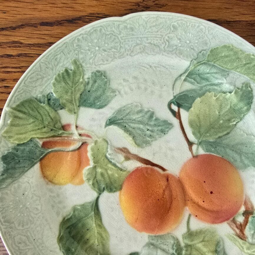 Assiette ancienne en barbotine St Clément, décor abricots en relief peint à la main – vue rapprochée