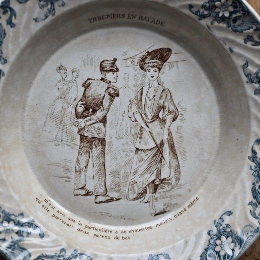 Plat creux ancien avec décor fleuri bleu et illustration de troupier – Digoin Sarreguemines