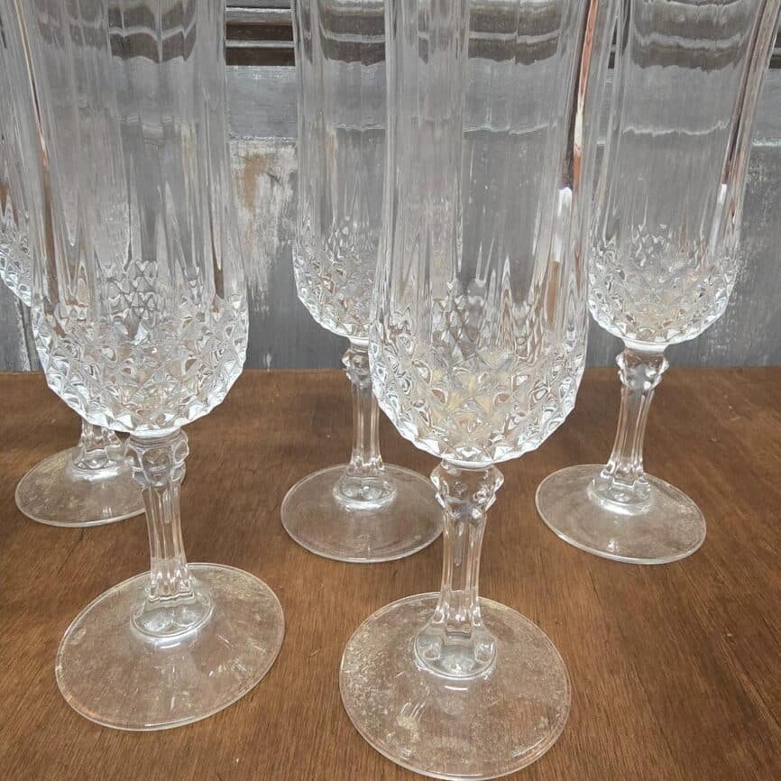 Flûte à champagne vintage en verre travaillé, vue rapprochée avec décor ciselé et pied nervuré.