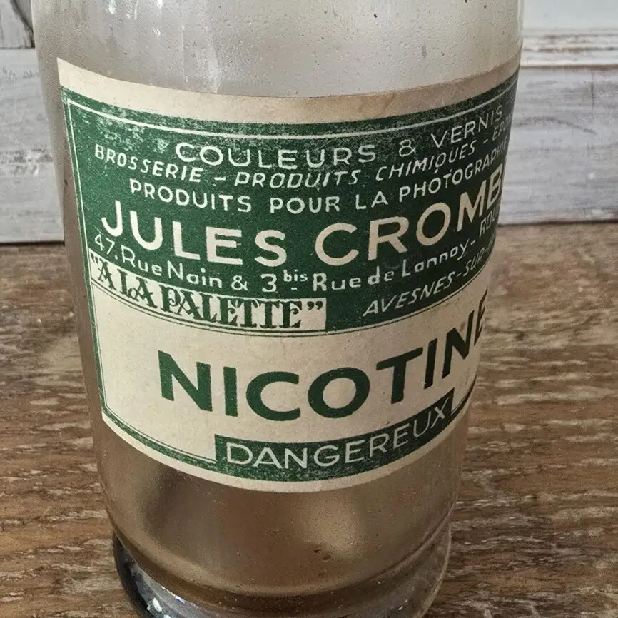 Gros plan sur l’étiquette verte « Jules Crombé – Produits chimiques – Roubaix » partie 1.