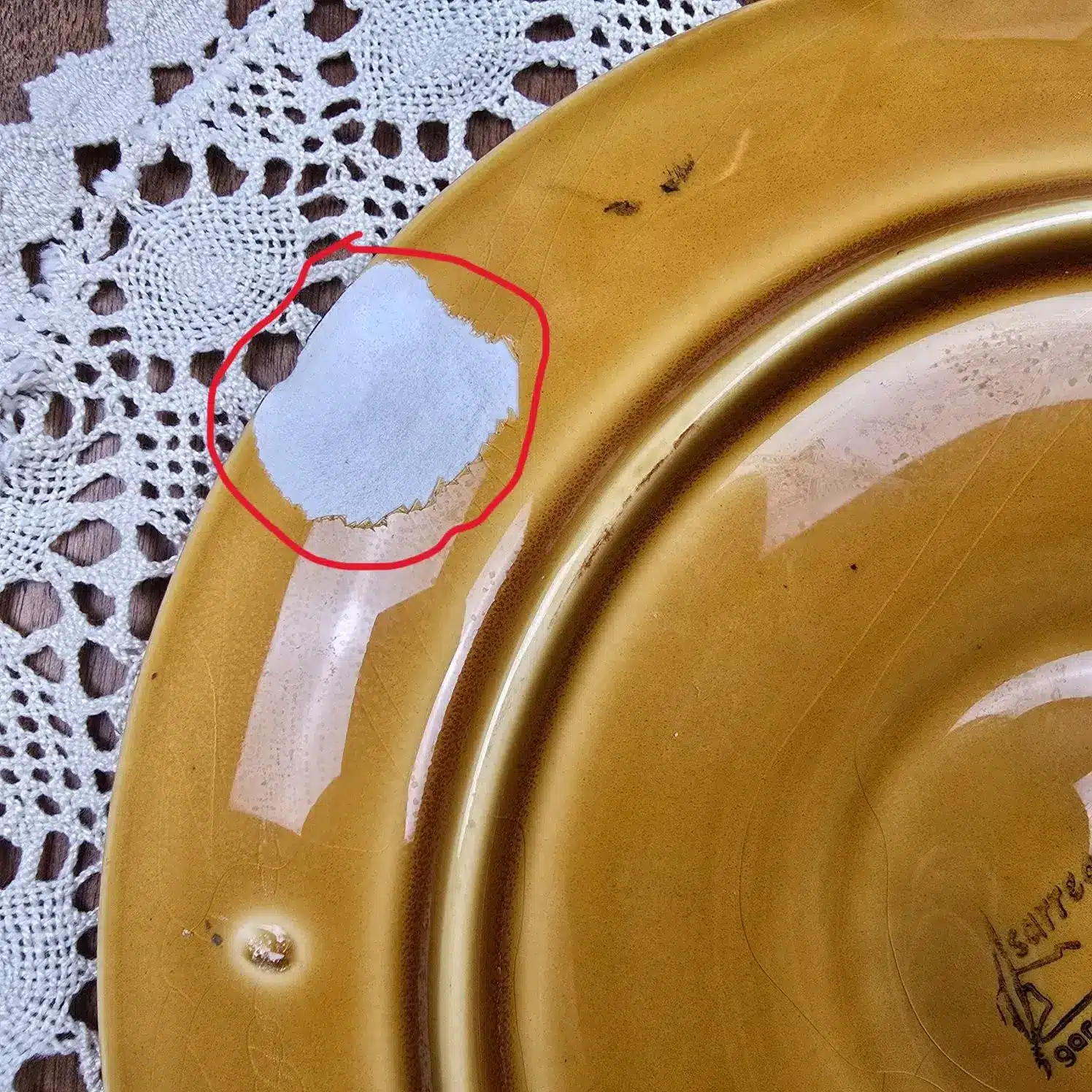 Dessous d’une assiette à huîtres Sarreguemines avec zones ébréchées visibles