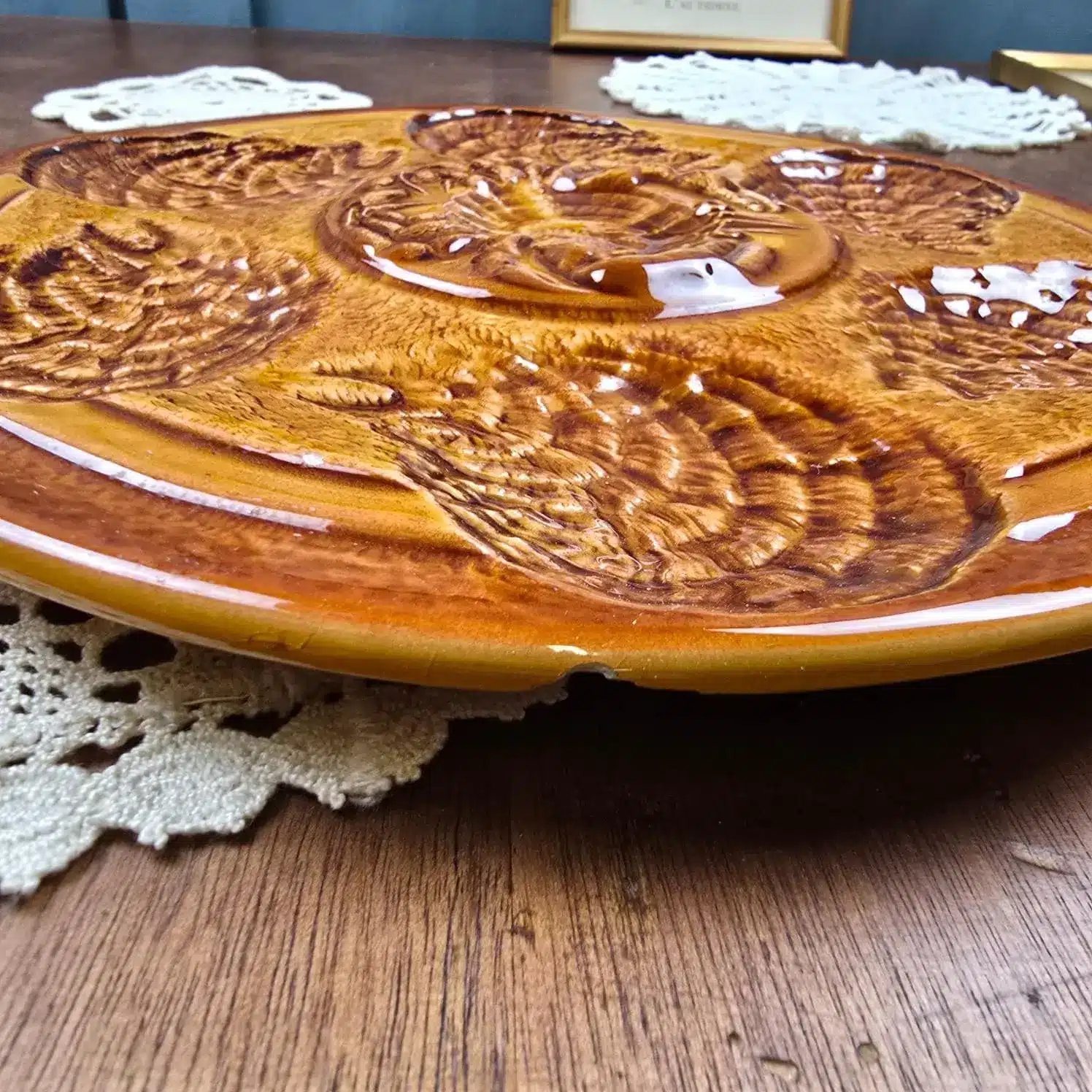 ssiette à huîtres Sarreguemines décor brun, posée sur napperon ancien