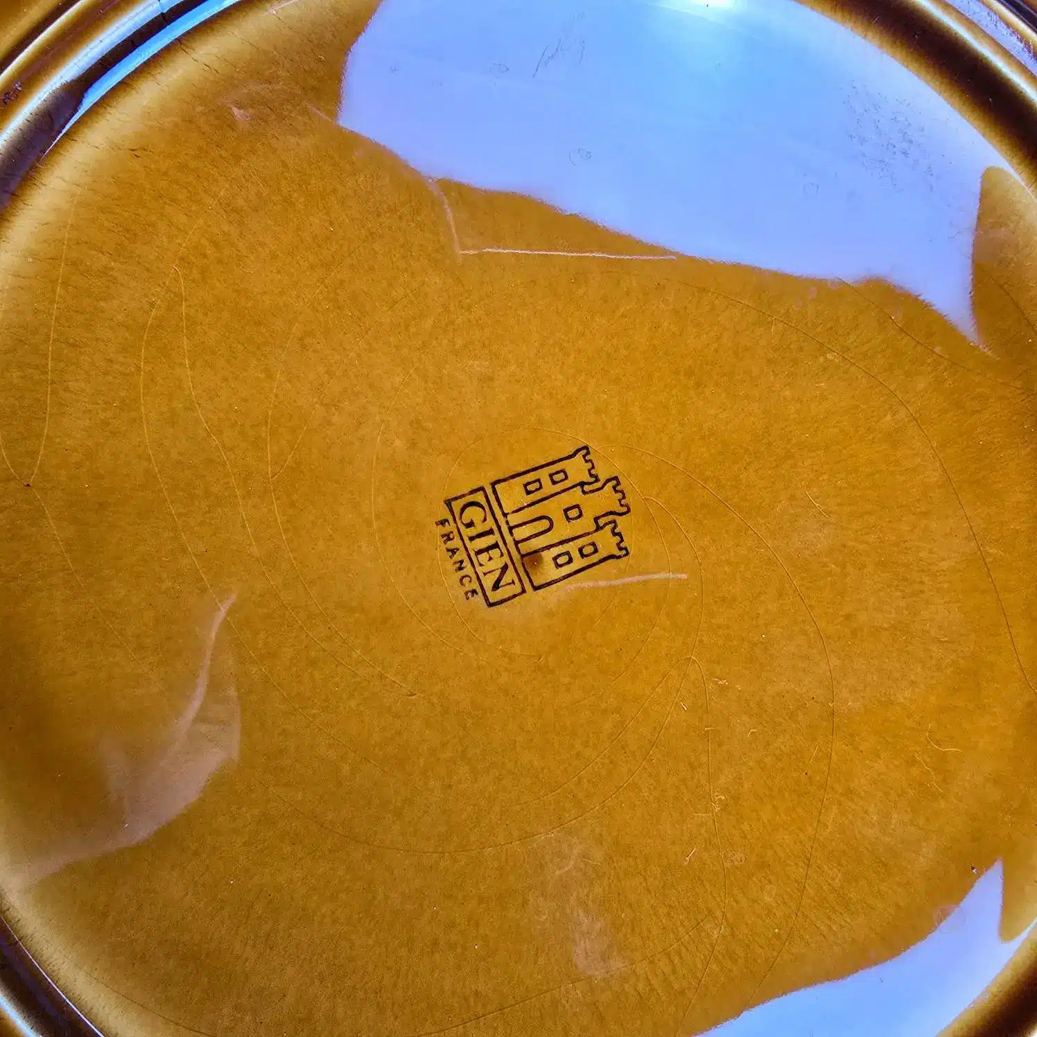 Estampille noire Gien France au dos d’une assiette en faïence.