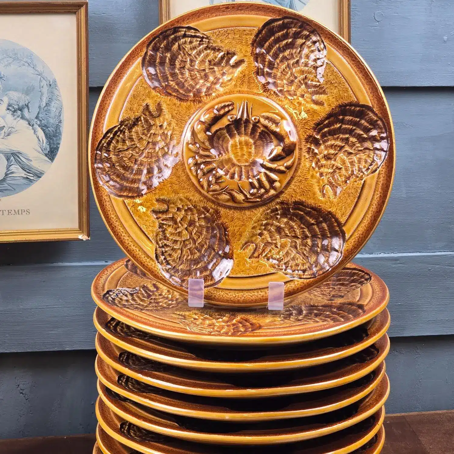 Gros plan sur les assiettes à huîtres Atelier du Revernay, décor crabes et coquillages en relief.