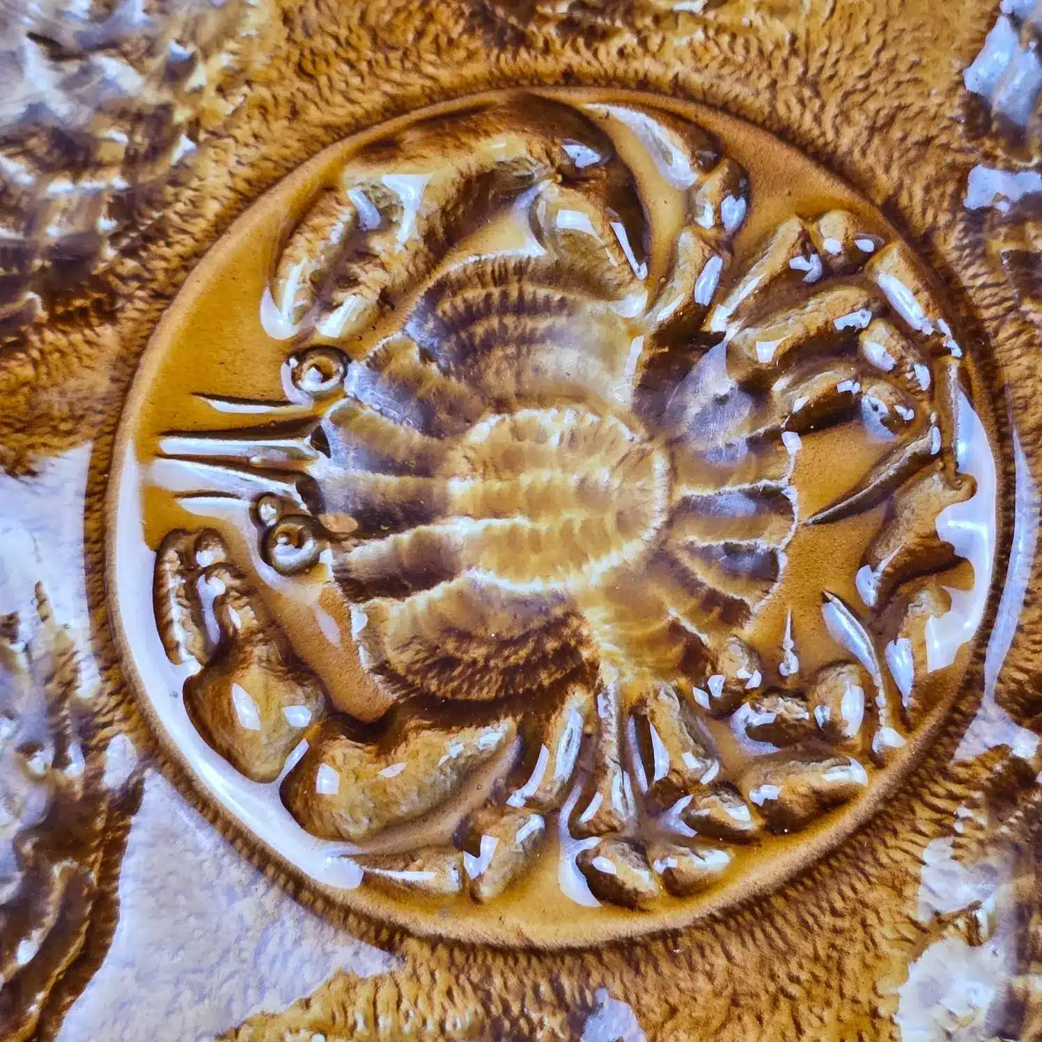 Gros plan sur le décor crabe central en relief des assiettes Atelier du Revernay France.