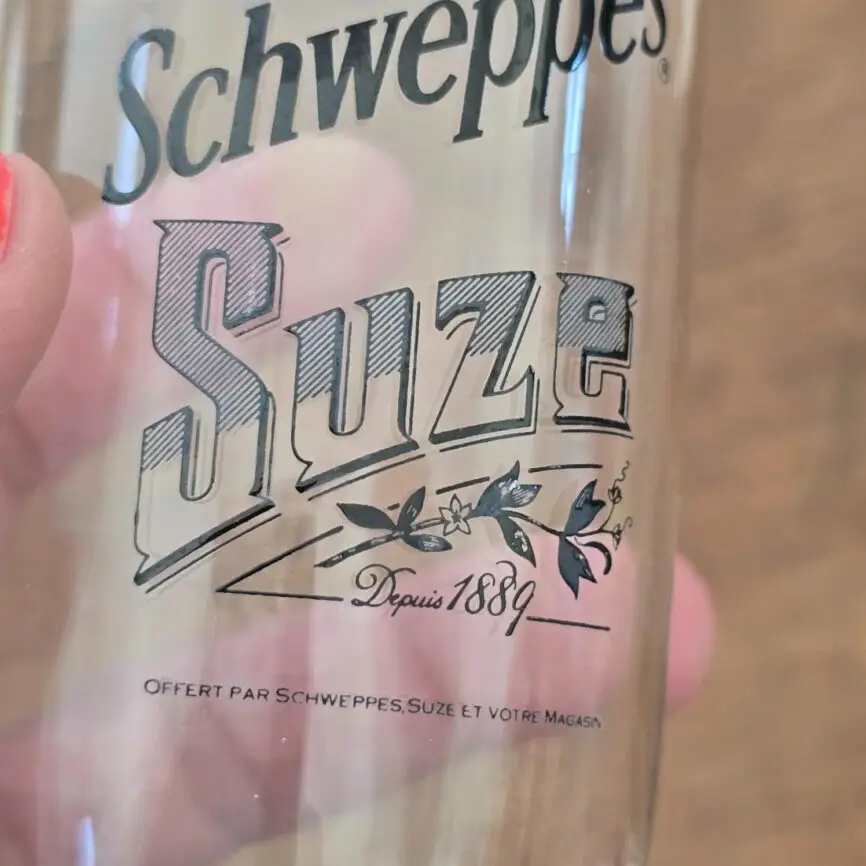 Zoom sur l'inscription d'un verre Schweppes Suze.