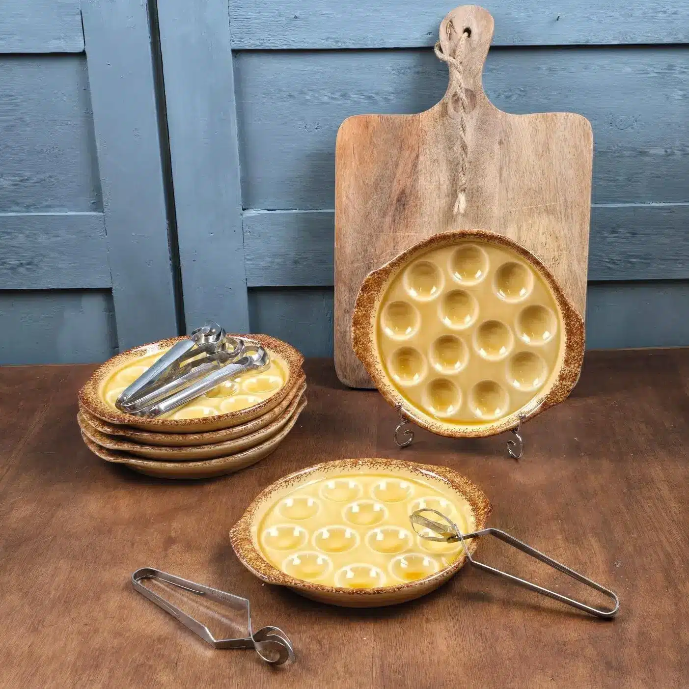 Ensemble complet d’assiettes à escargots Gien avec leurs pinces en acier inox.