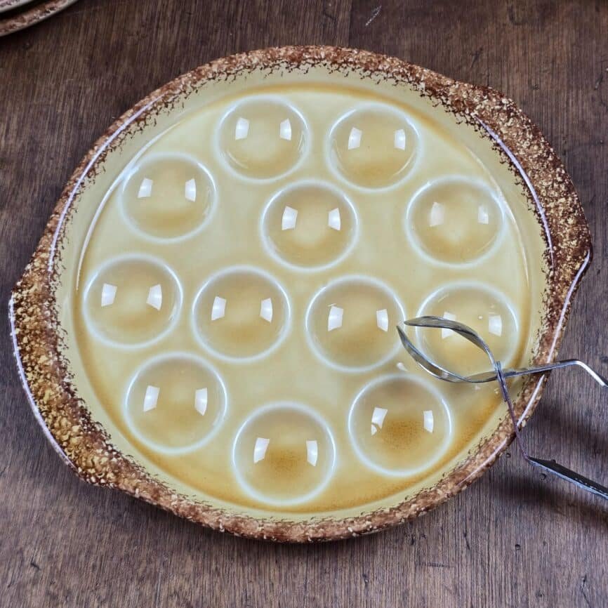 Vue de dessus d’une assiette à escargots Gien en faïence brun miel.