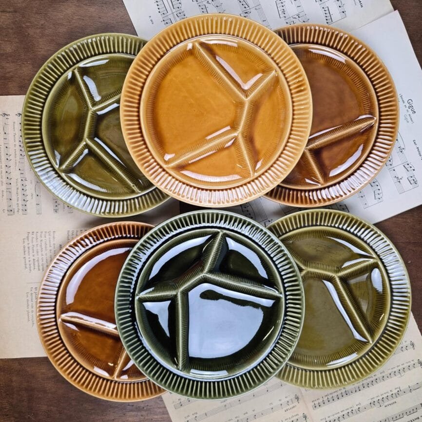 Ensemble complet des six assiettes à fondue Sarreguemines sur table en bois, ambiance rétro et conviviale.