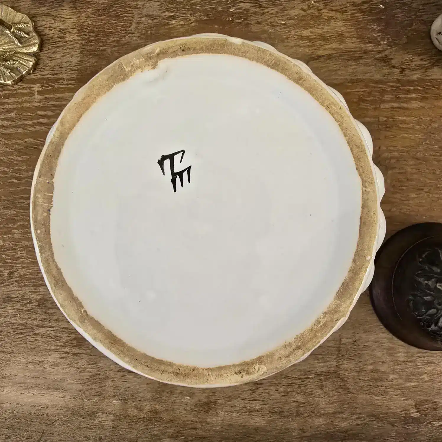 Signature Émile Teissier Malicorne sous le dessous du cache-pot en faïence blanche