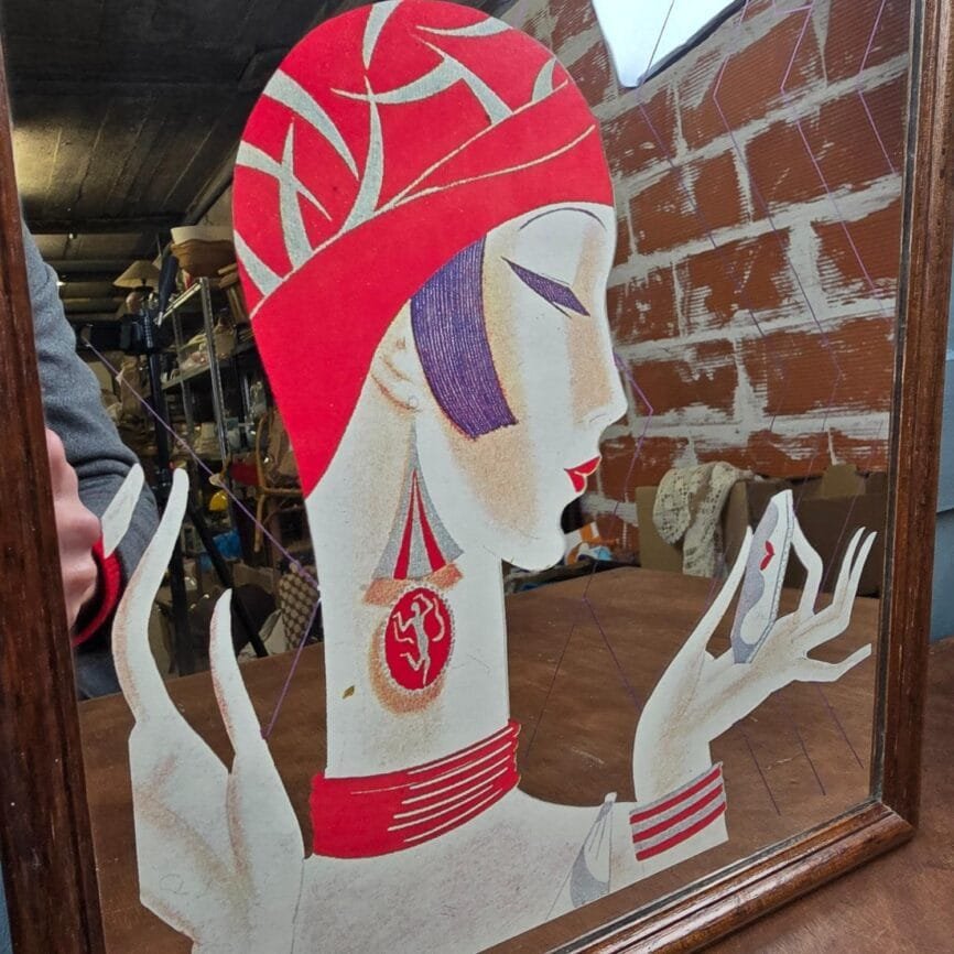 Détail du visage féminin sur le miroir VOGUE, teintes rouge et violet.