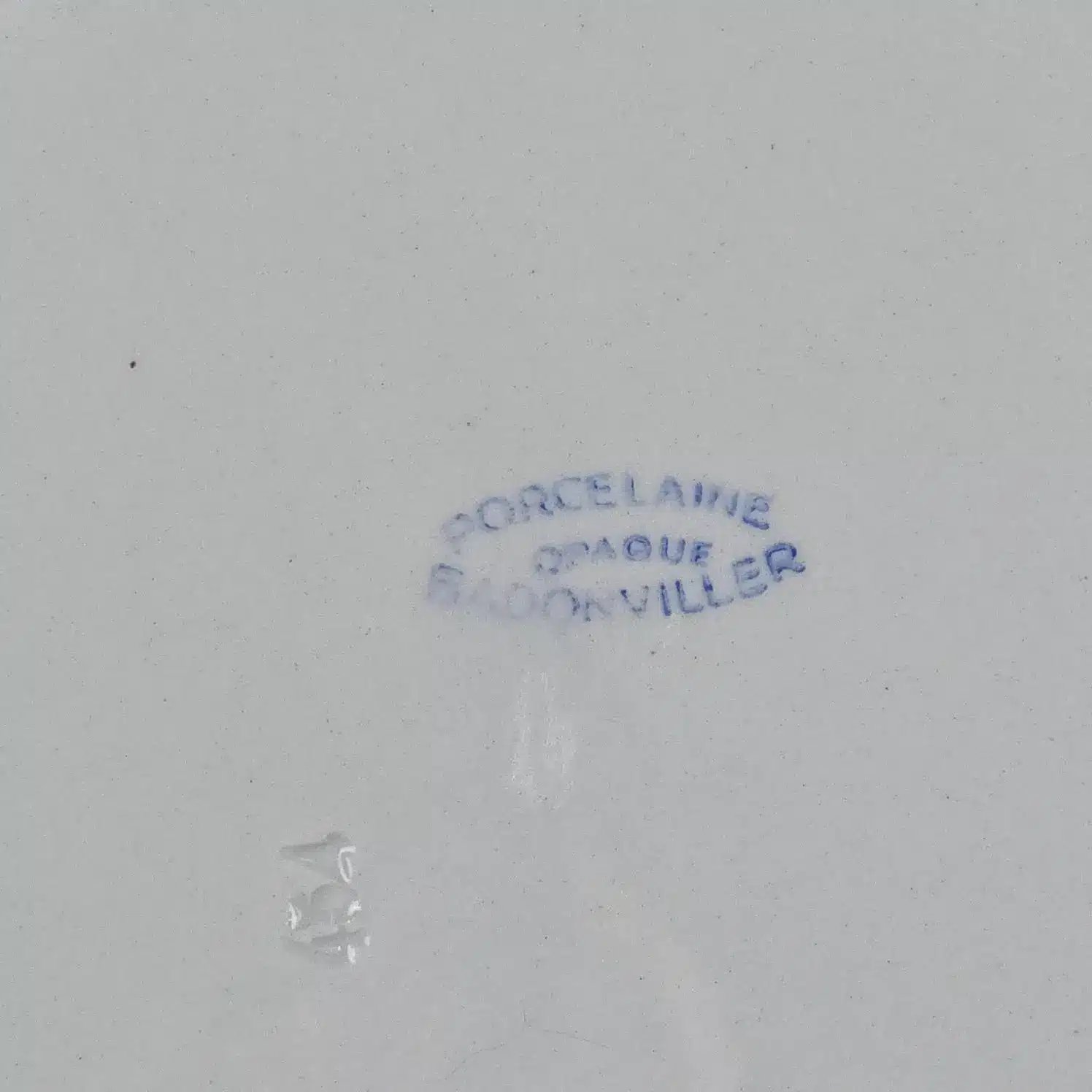 stampille bleue « Porcelaine Opaque Badonviller » visible sous le dessous du plat.