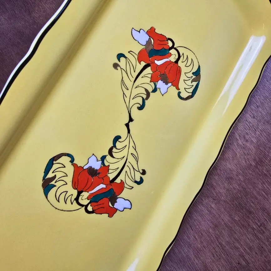 Détail du motif floral peint à la main sur faïence jaune Longwy Panache