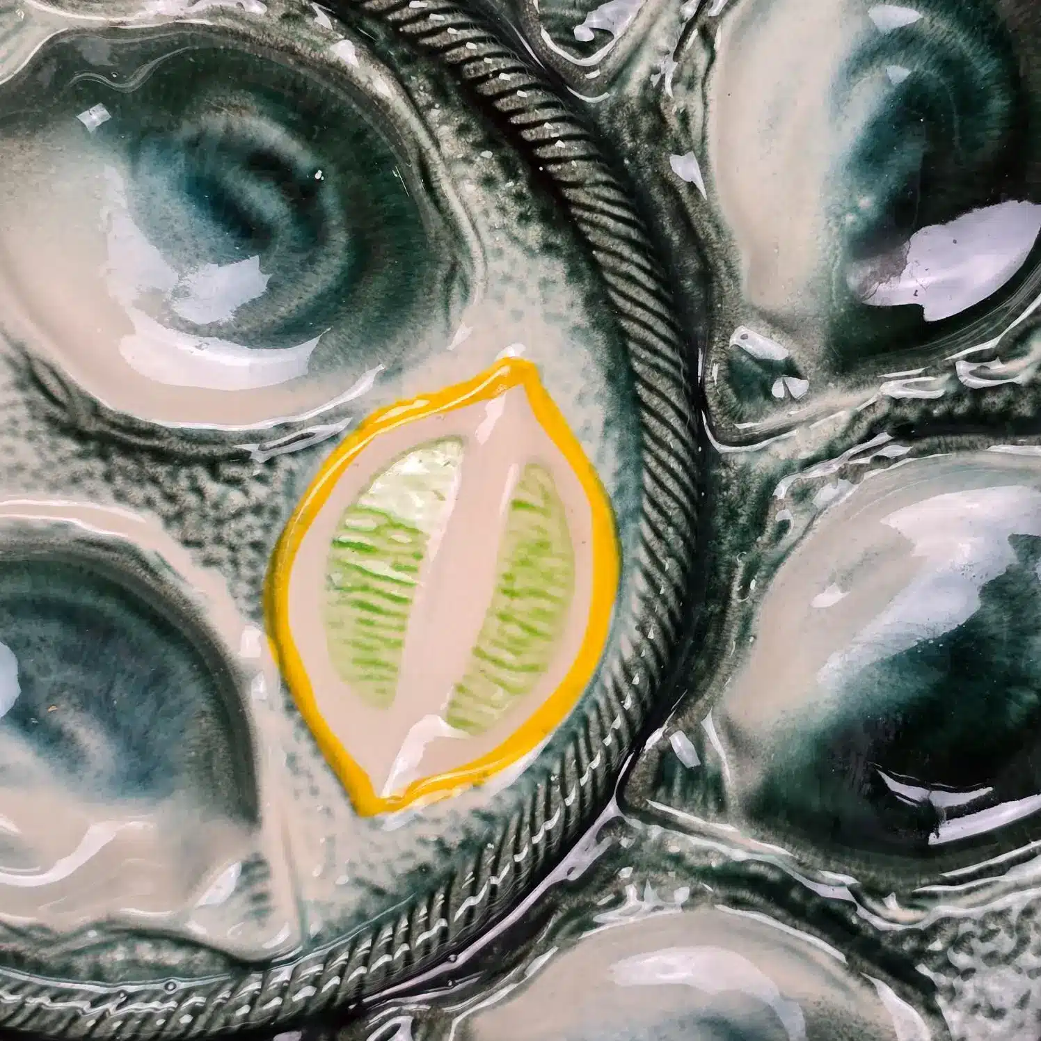 Détail du décor en relief vert et jaune sur plat à huîtres St Clément