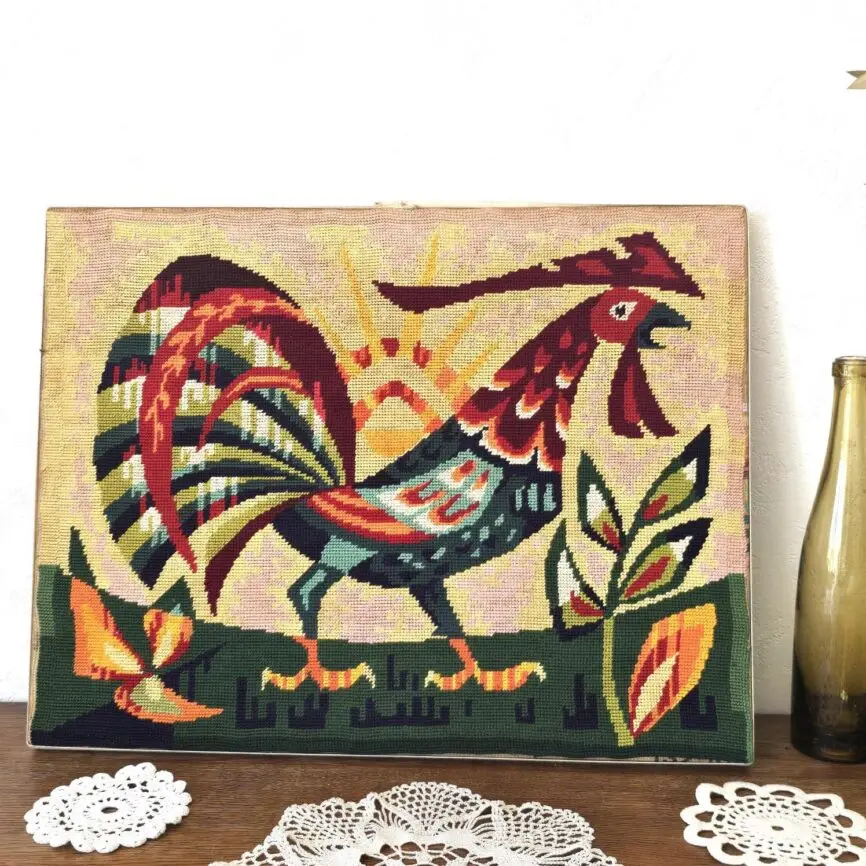 Tapisserie vintage brodée main représentant un coq coloré stylisé sur fond soleil levant