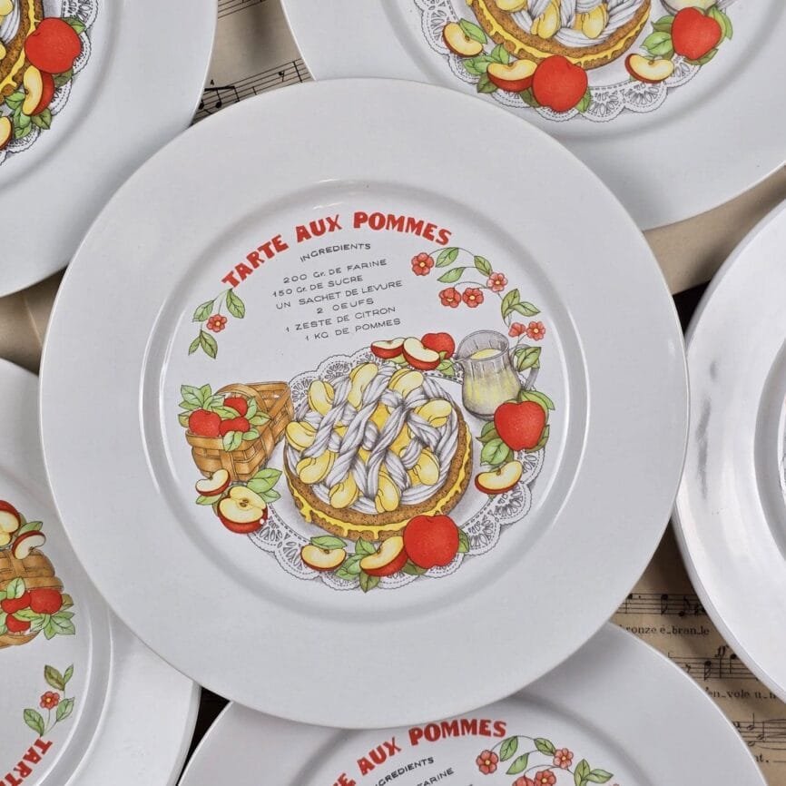 Vue rapprochée d’une assiette « Tarte aux pommes » avec illustration et recette imprimée.