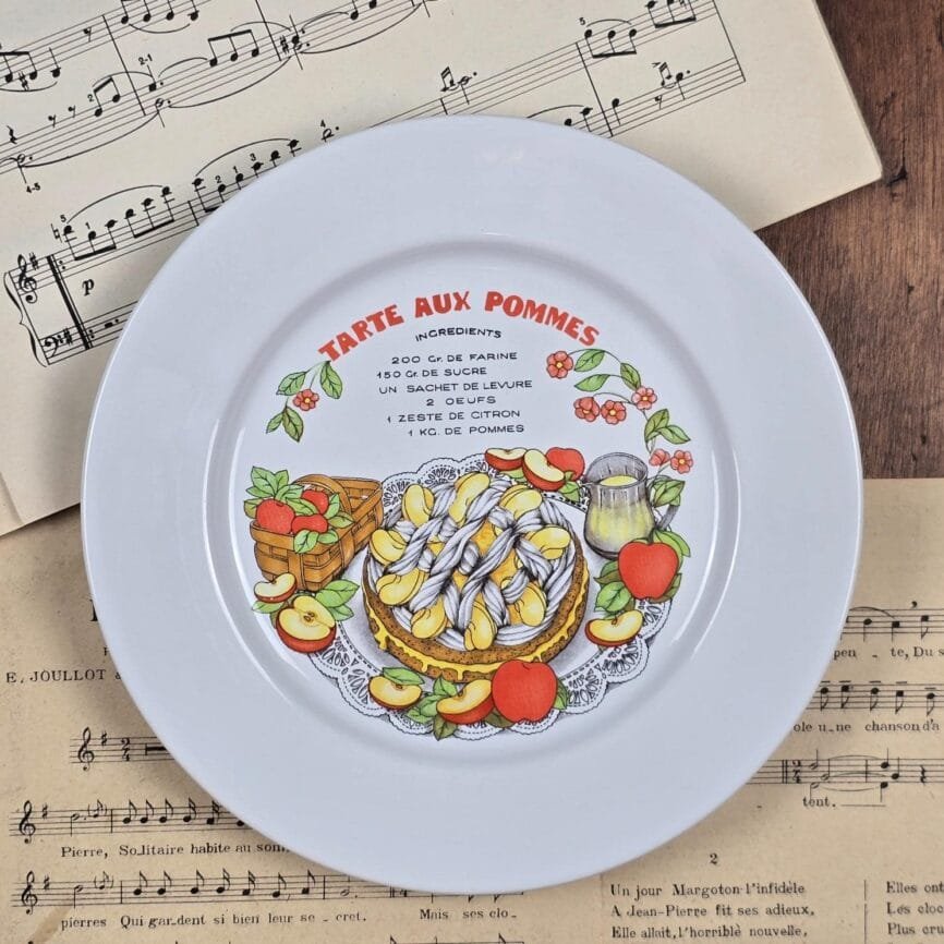 Assiette individuelle « Tarte aux pommes » photographiée sur fond de partitions.