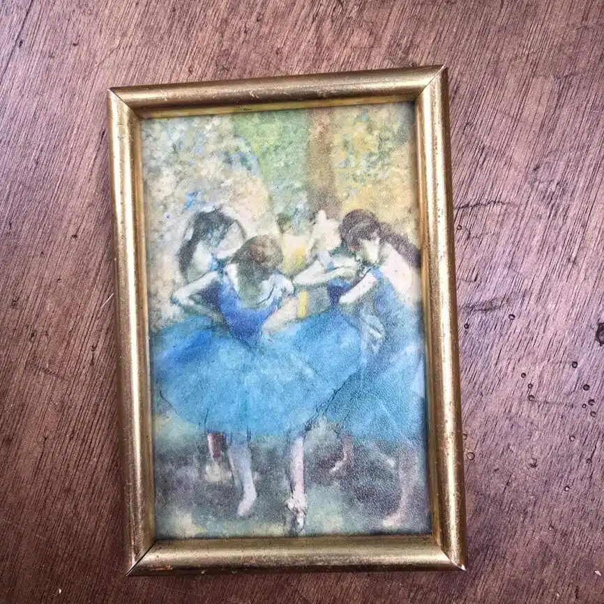 Gros plan sur la reproduction des danseuses bleues et le cadre doré patiné.