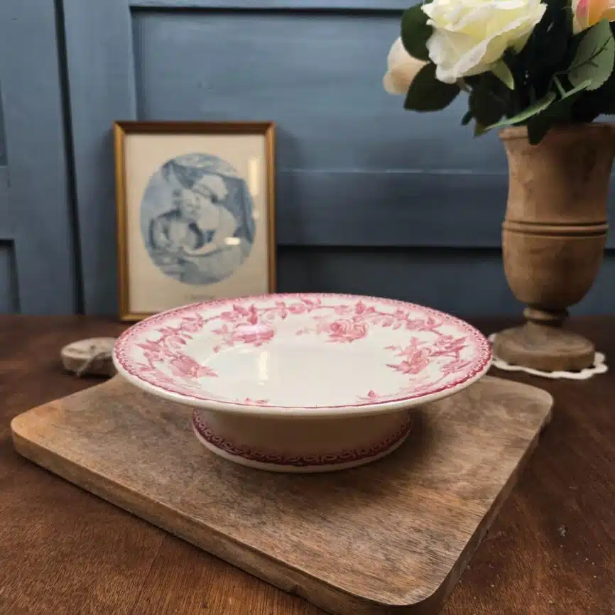 Compotier ancien HB & Cie décor roses posé sur une planche en bois.