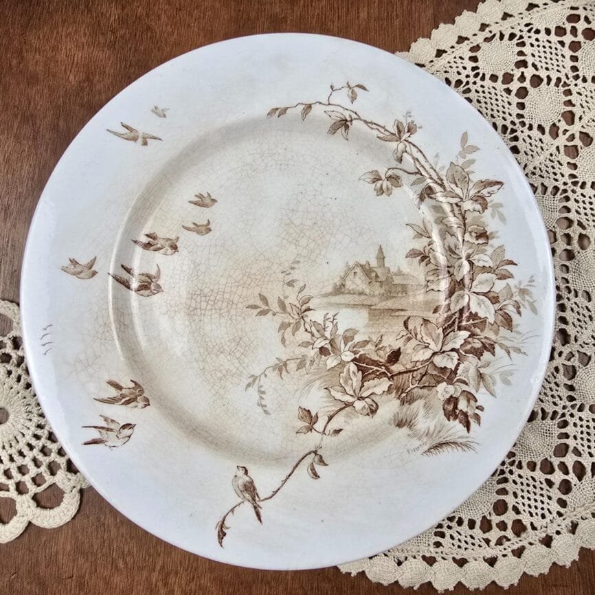 Vue de dessus du plat ancien sur pied décor sépia bucolique.