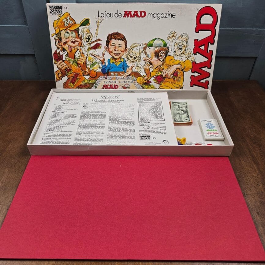 Vue intérieure de la boîte avec plateau, carte, pions et billets MAD Money.