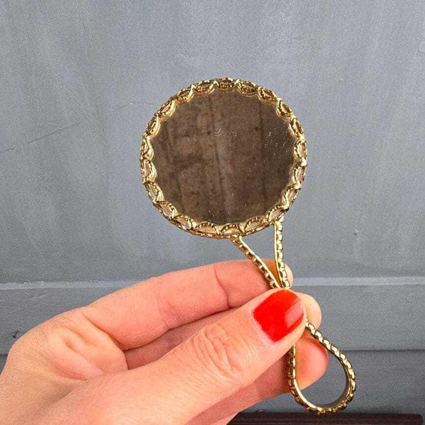 Miroir de sac Limoges tenu en main, décor bleu et jaune lumineux.