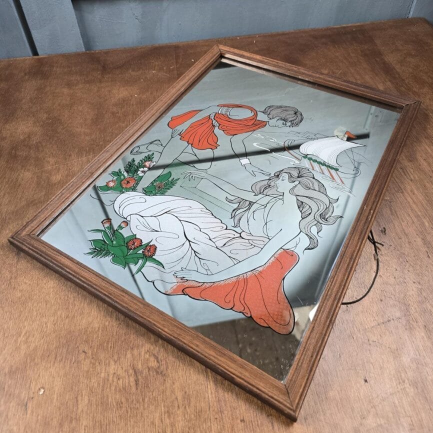 Vue latérale du miroir posé sur table en bois, reflets vintage.