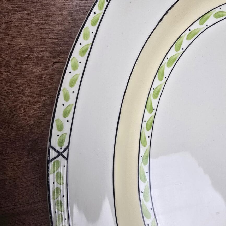 Zoom sur le décor peint en vert et crème du plat anglais.