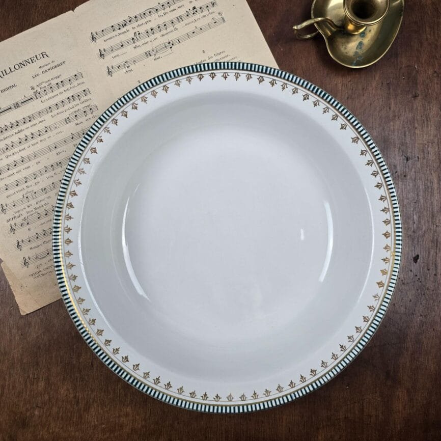 Plat ancien Sarreguemines & Digoin ARCOLE posé sur une table en bois avec une partition ancienne.