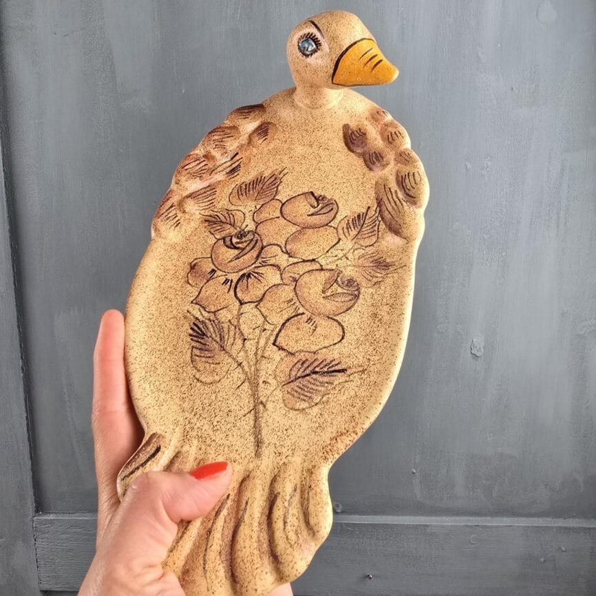 Plat tenu à la main montrant la texture sablée et le relief du décor.