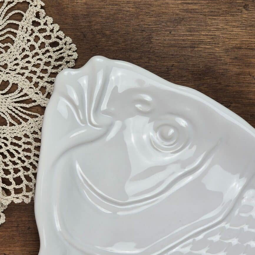 Détail de la tête du poisson en porcelaine blanche, relief et brillance.