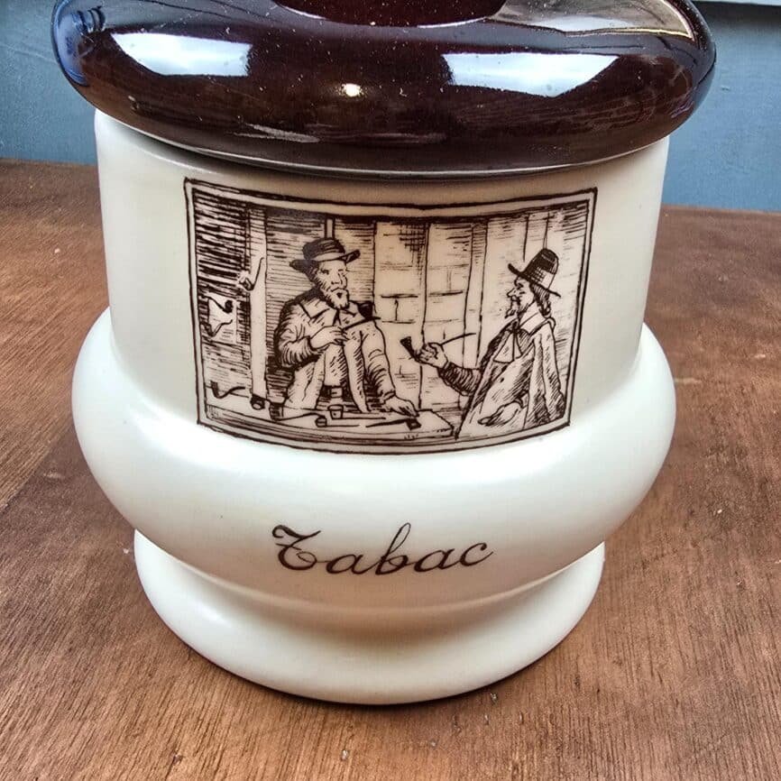 Zoom sur la typographie et le décor brun du pot à tabac.