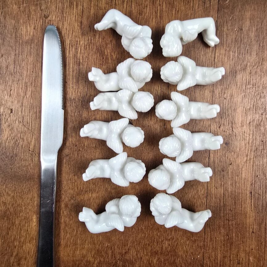 Vue du dessus montrant les 12 repose-couteaux anges alignés.