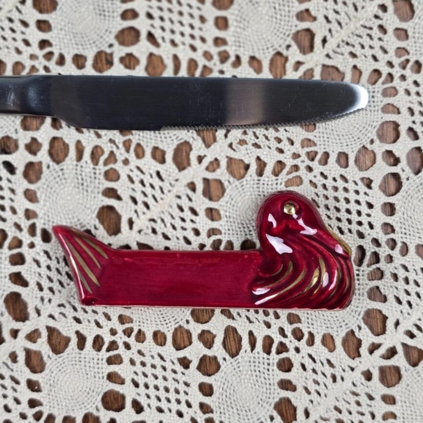 Repose-couteaux en céramique forme canard couleur bordeaux et doré.