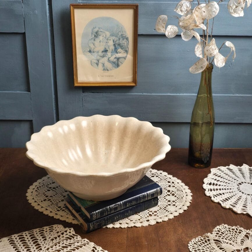 Grand saladier ancien Jules Vieillard & Cie Bordeaux en porcelaine opaque, forme coquillage, posé sur napperon crochet.