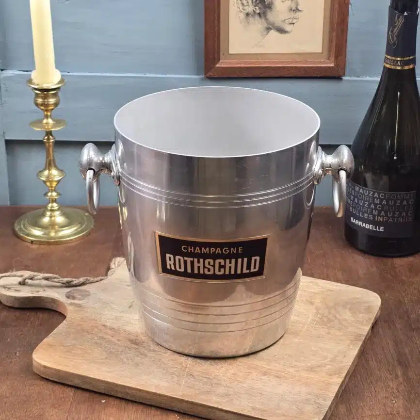 Seau à champagne Rothschild ancien posé sur une planche en bois, ambiance bistrot chic.