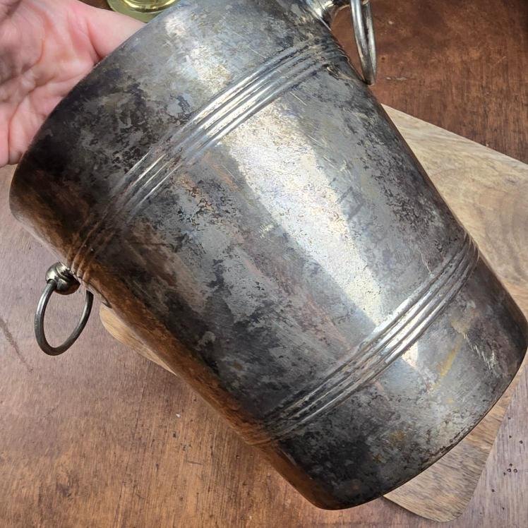 Gros plan sur la patine argentée texturée du seau.