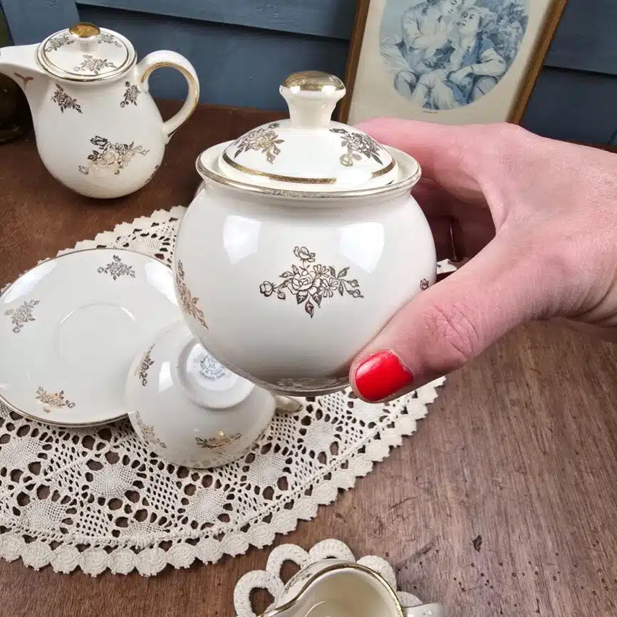 Vue rapprochée du petit sucrier décoré d’un motif doré.