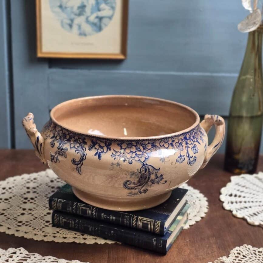 Bas de soupière ancien Boulenger & Cie Choisy-le-Roi, modèle Wild Rose, décor floral bleu sur fond beige patiné, posé sur des livres anciens.