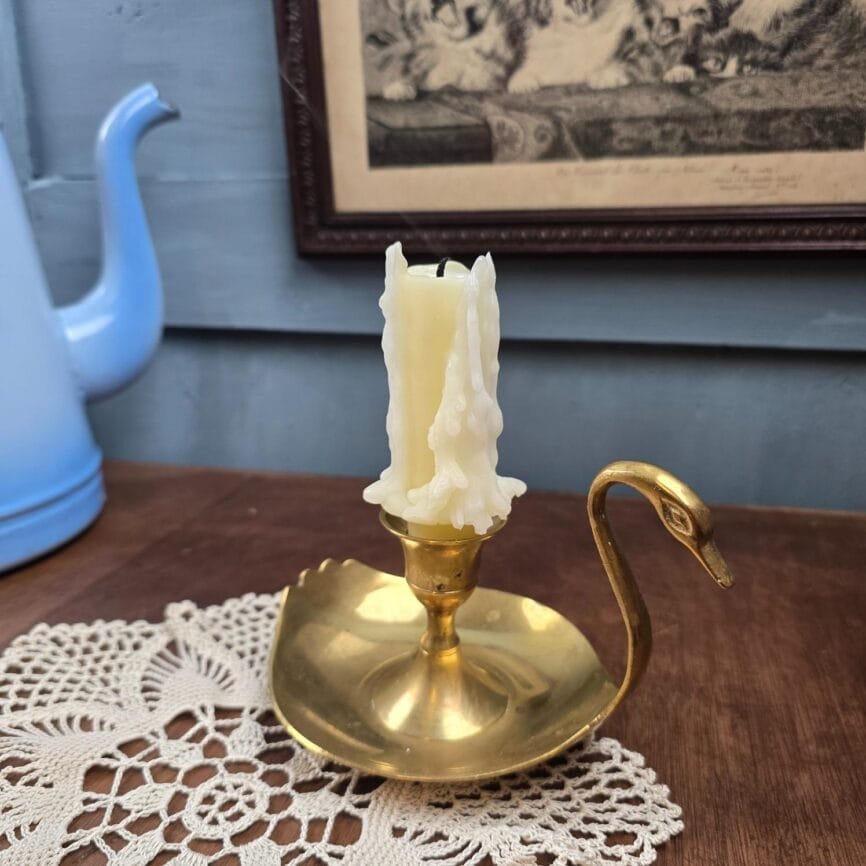 Bougeoir en laiton en forme de cygne, vue de profil sur fond neutre, esprit déco vintage.