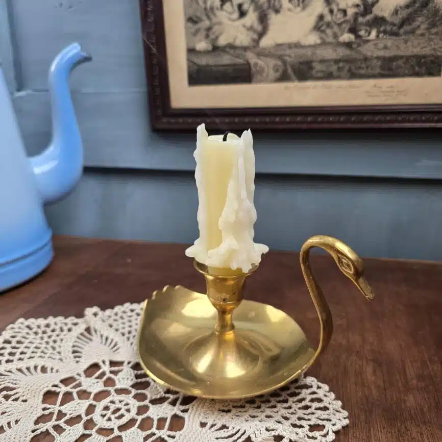 Bougeoir en laiton en forme de cygne, vue de profil sur fond neutre, esprit déco vintage.