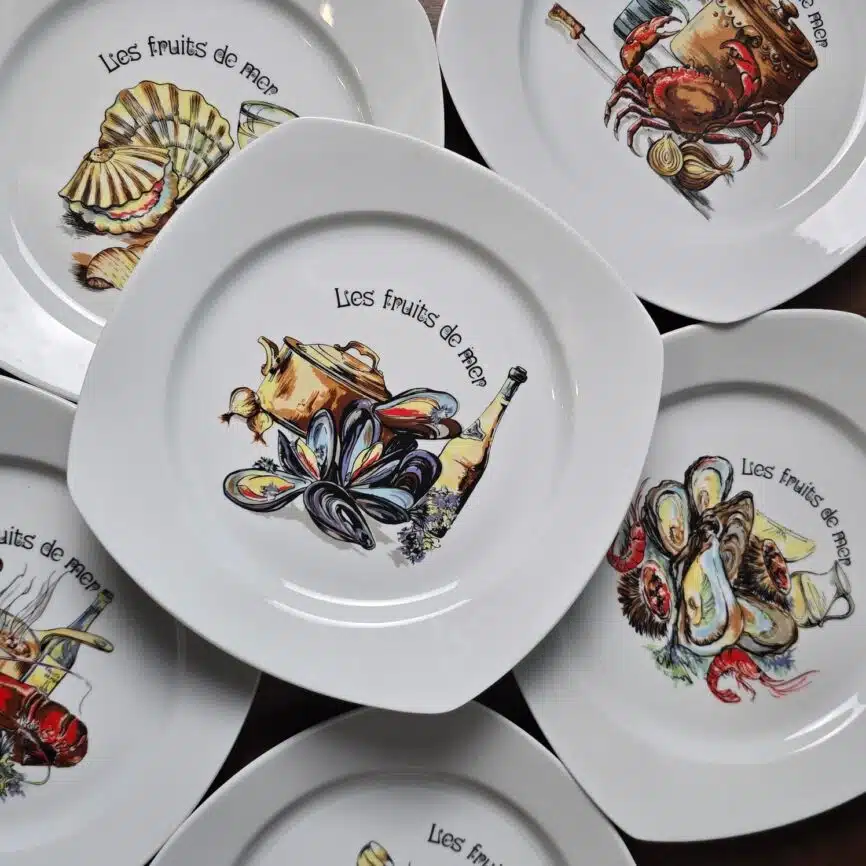 Lot de six assiettes anciennes en porcelaine de Brémaille, décor “Les fruits de mer”, motifs variés et couleurs vives.