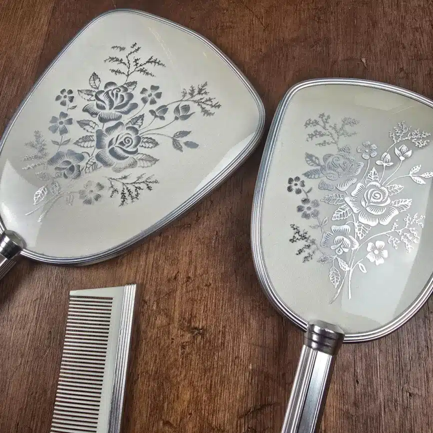 Détail du décor floral argenté sur le miroir et la brosse Mascot London