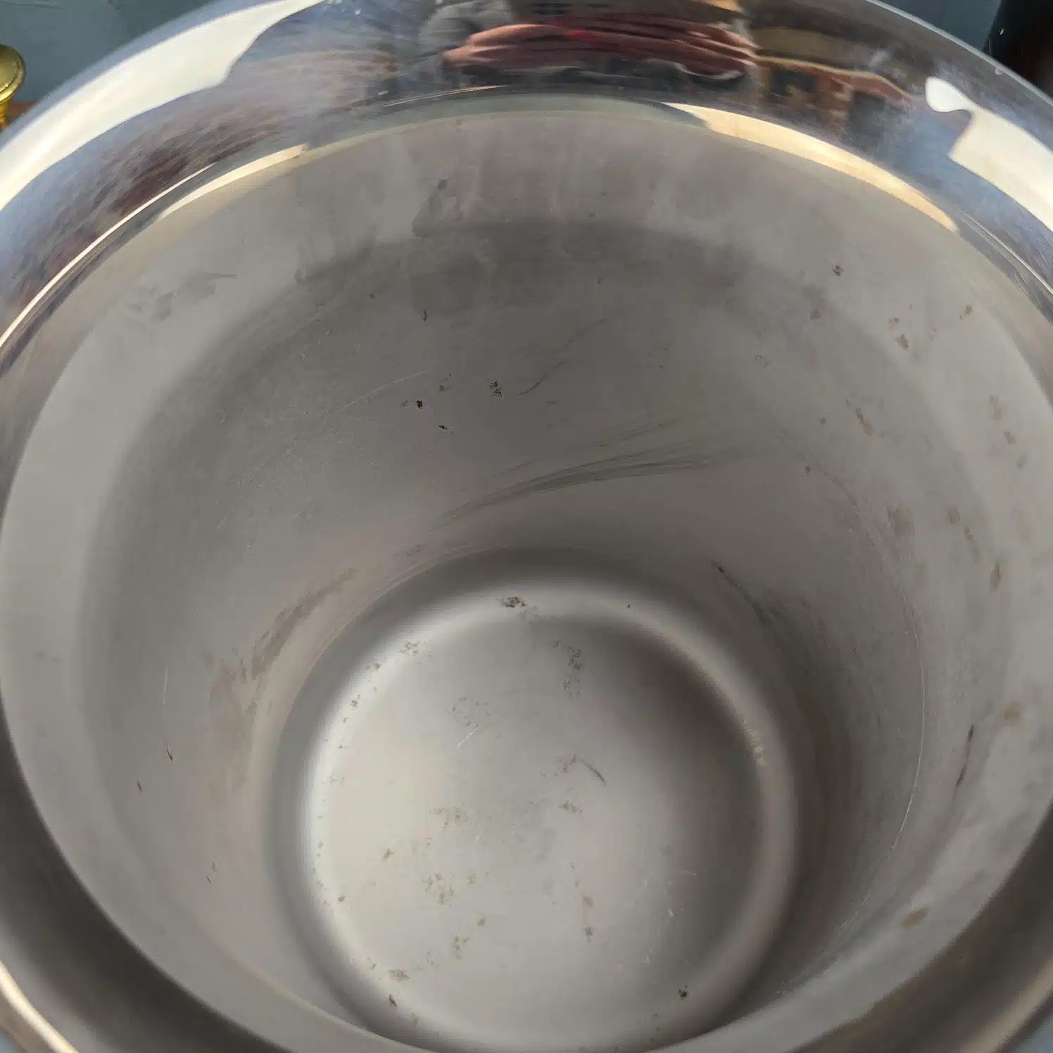 Zoom sur l'ntérieur du seau à champagne Jean Couzon en inox brossé avec traces d’usage.