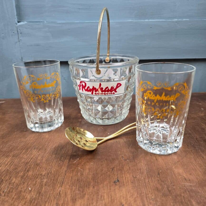 Vue du dessus de l’ensemble avec la cuillère dorée posée au-dessus du seau à glaçons.