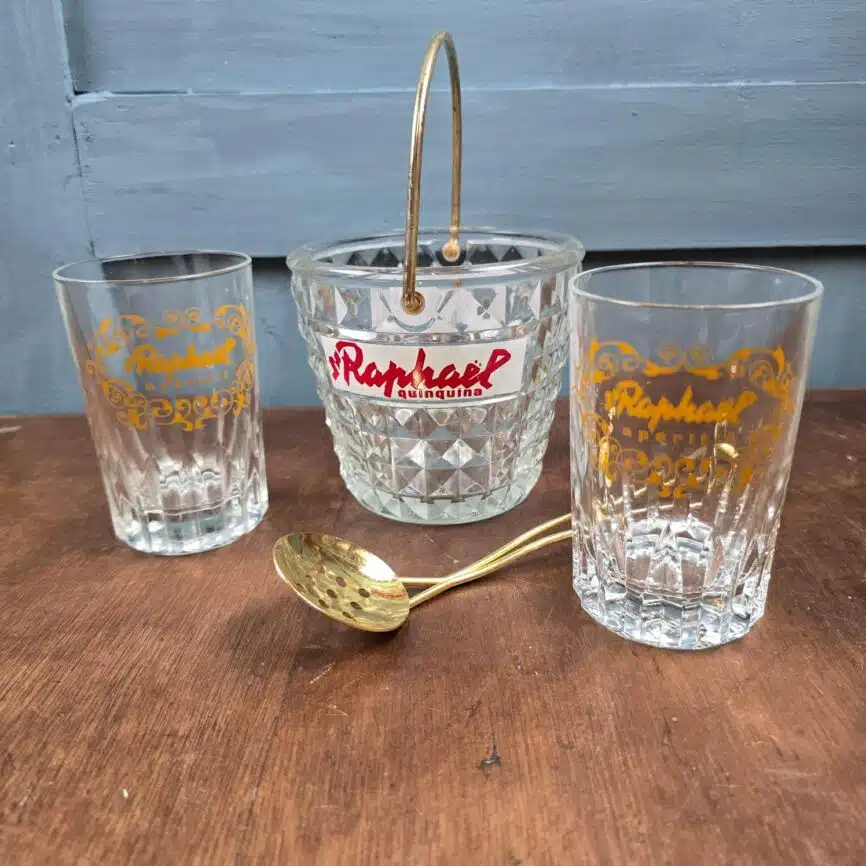 Vue du dessus de l’ensemble avec la cuillère dorée posée au-dessus du seau à glaçons.