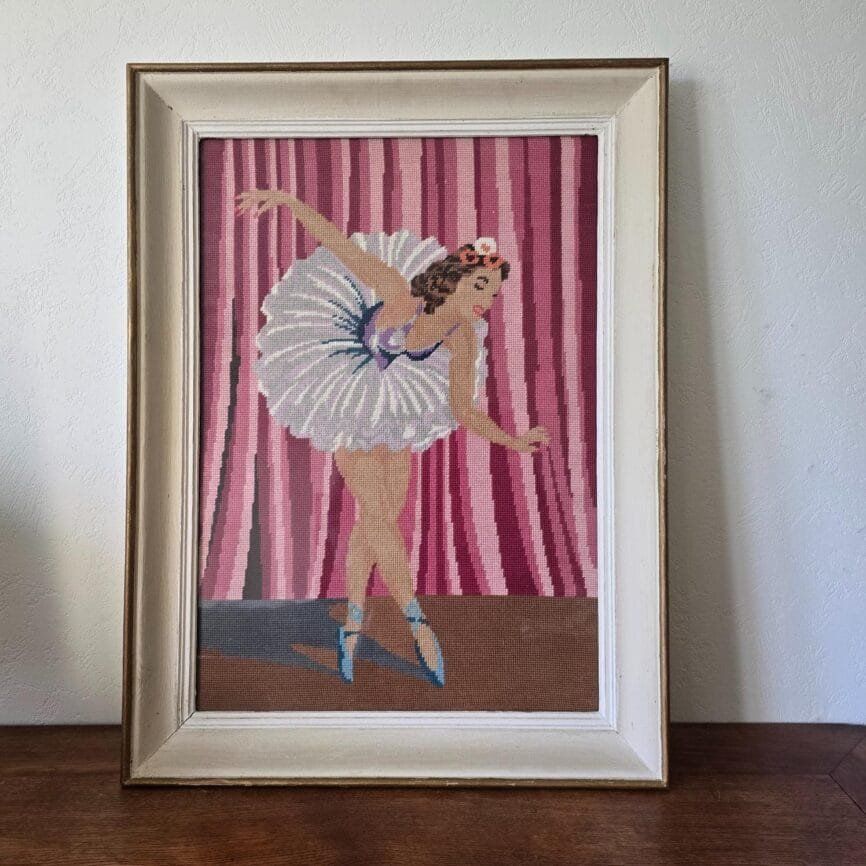 Grand cadre vintage avec point de croix représentant une danseuse en mouvement sur fond rose et violet