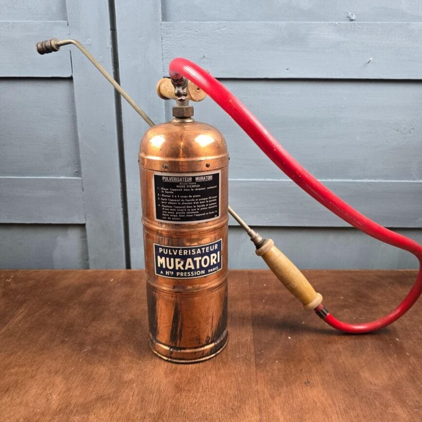 Pulvérisateur Muratori en cuivre avec lance et tuyau rouge, vue d’ensemble