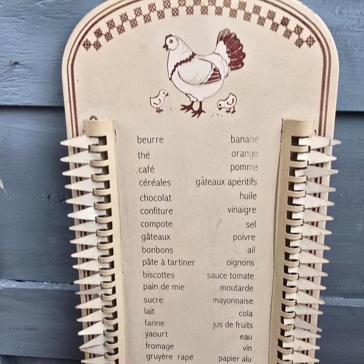 Vue rapprochée de la poule sur mémo courses en métal patiné