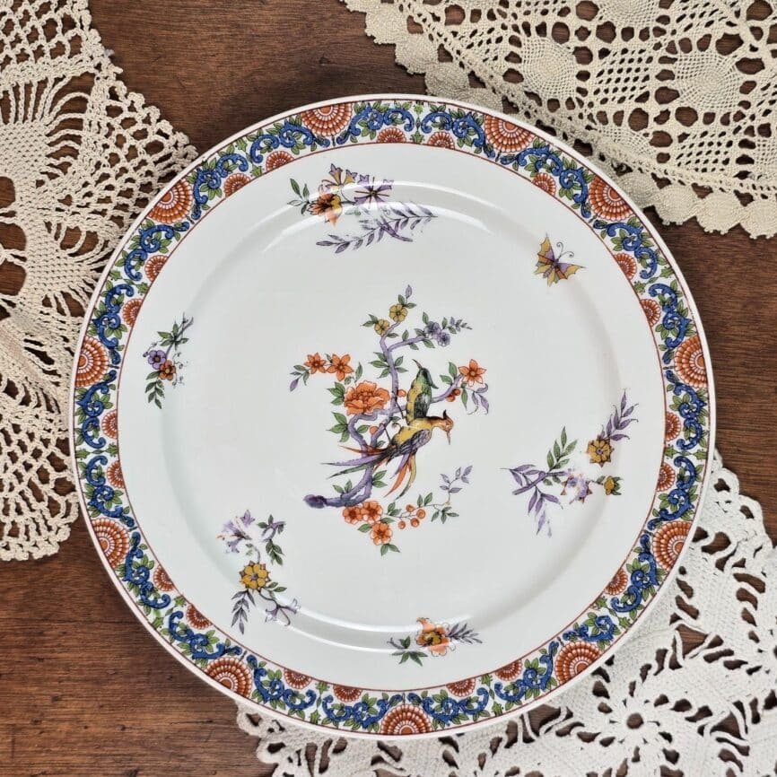 assiettes limoges décor oiseau en porcelaine sur table en bois avec napperons